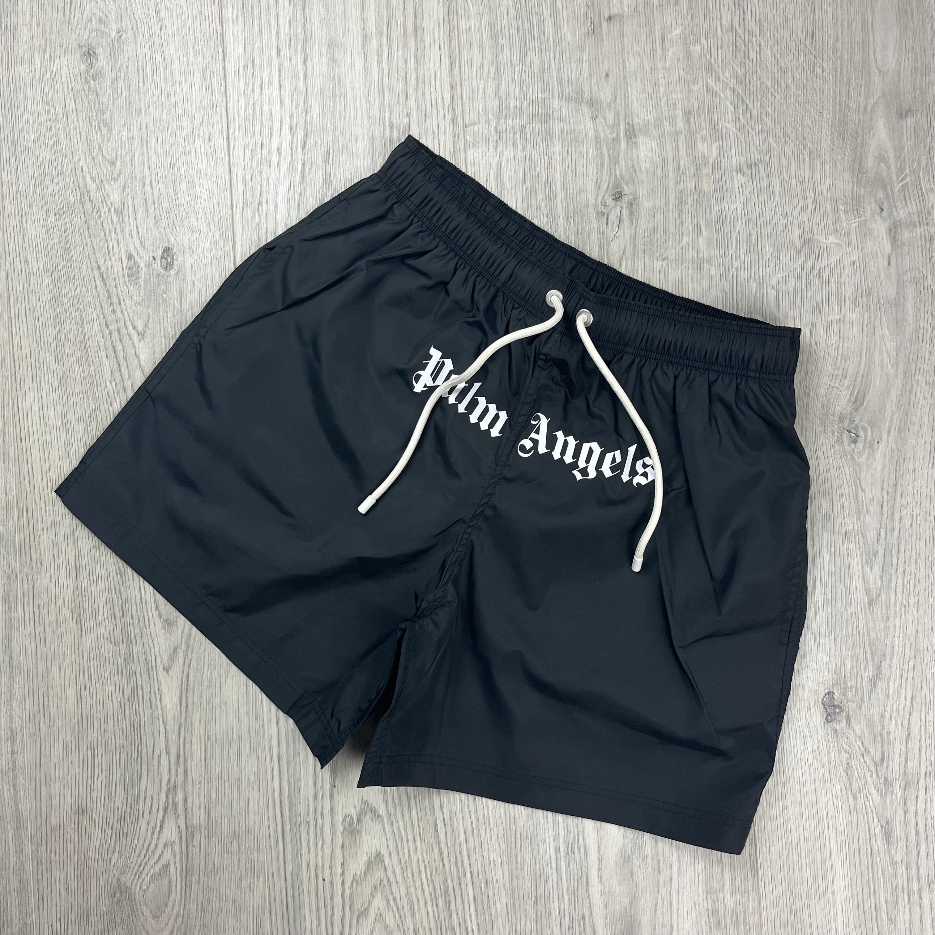 Palm Angels Gothic Logo Swim Shorts in Black. On sale at Open Attire.
