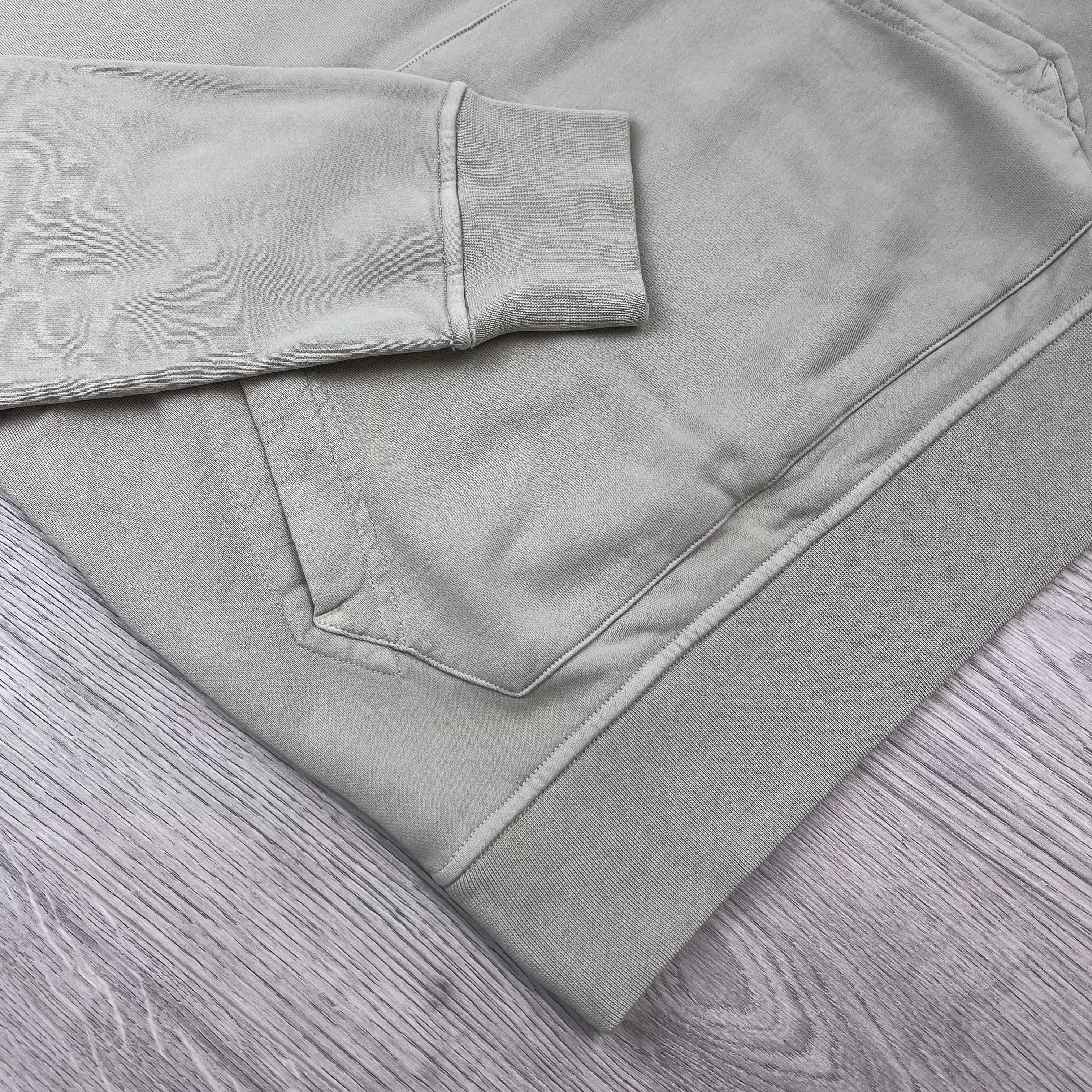 A close view of the elasticated hem and cuff on a Stone Island Pullover Hoodie in Sand. 