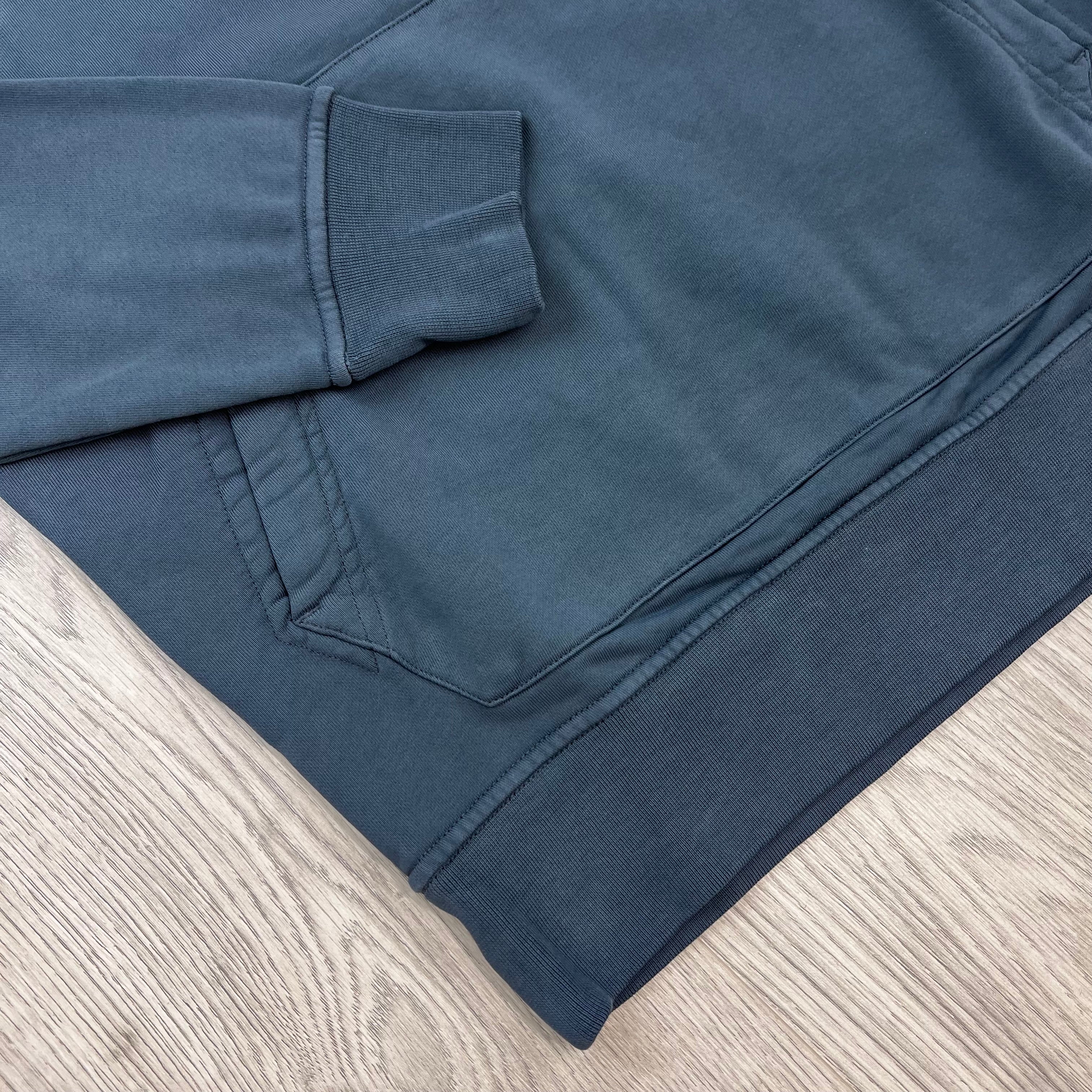 A close view of the elasticated hem and cuff on a Stone Island Pullover Hoodie in Slate Blue. 