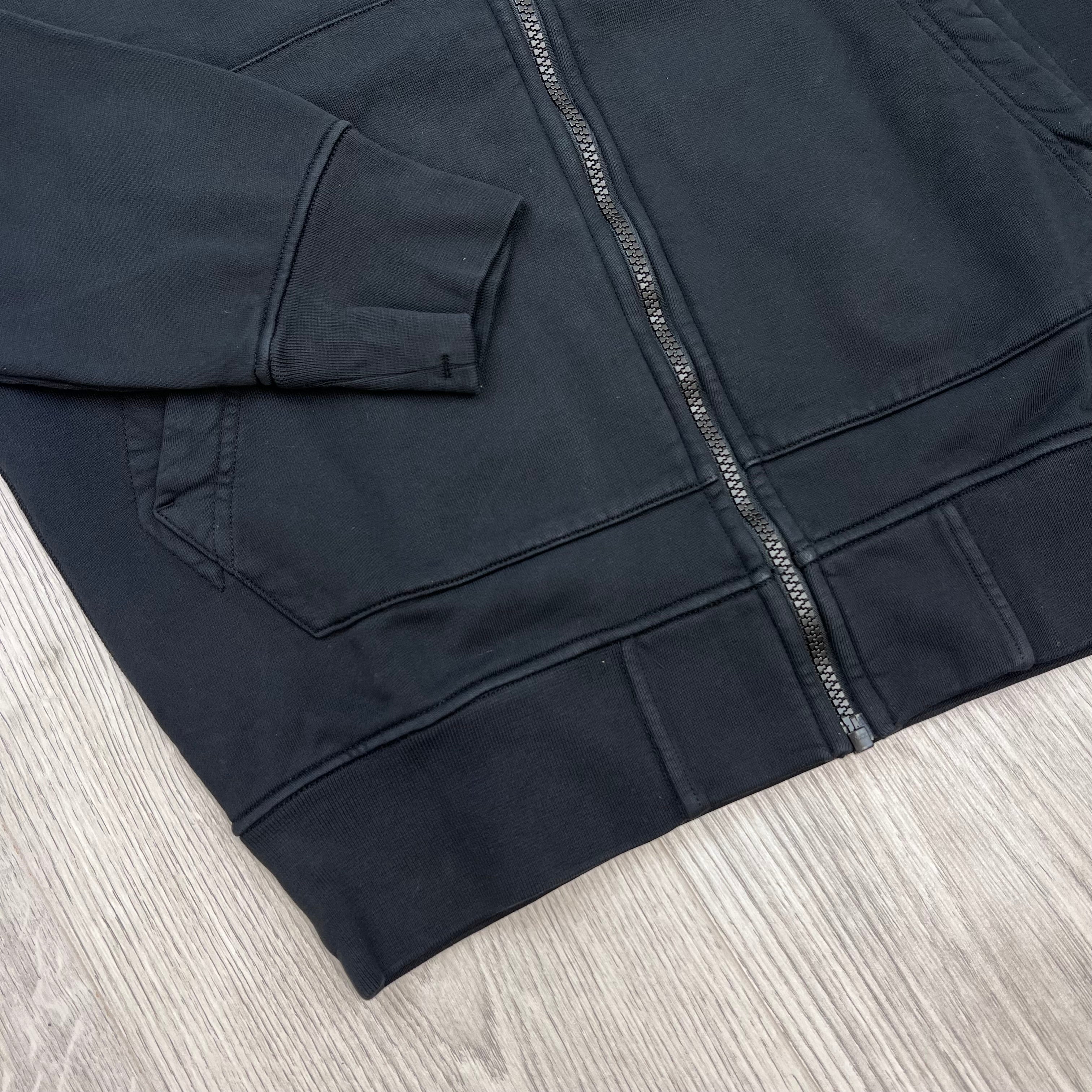 A close up view of the elasticated hem and cuff on the Stone Island Zip Hoodie in Black. 